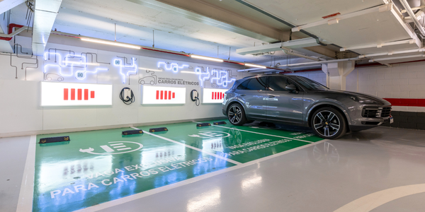 imagem mostra três vagas de estacionamento para carros elétricos.